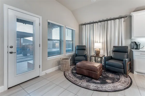 a living room with furniture and a large mirror next to a window