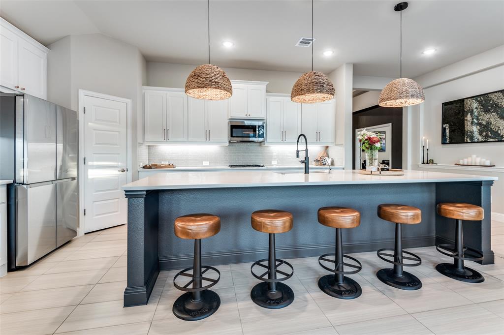 425 Acadia Lane Forney, TX 75126 - Photo 12 of 37 a kitchen with stainless steel appliances a kitchen island a stove and a sink