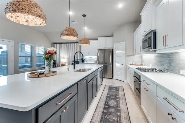 a kitchen with kitchen island granite countertop a sink and a stove