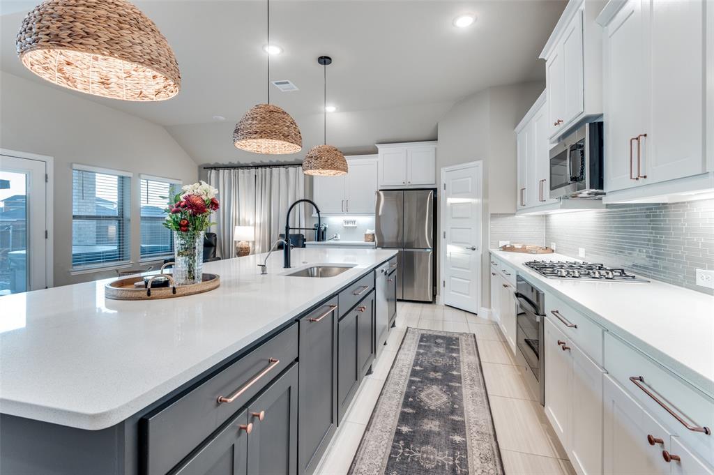 425 Acadia Lane Forney, TX 75126 - Photo 14 of 37 a kitchen with kitchen island granite countertop a sink and a stove