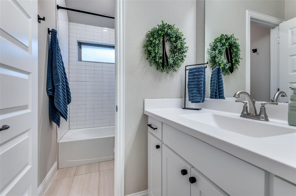 425 Acadia Lane Forney, TX 75126 - Photo 23 of 37 a bathroom with a sink a potted plant and a mirror