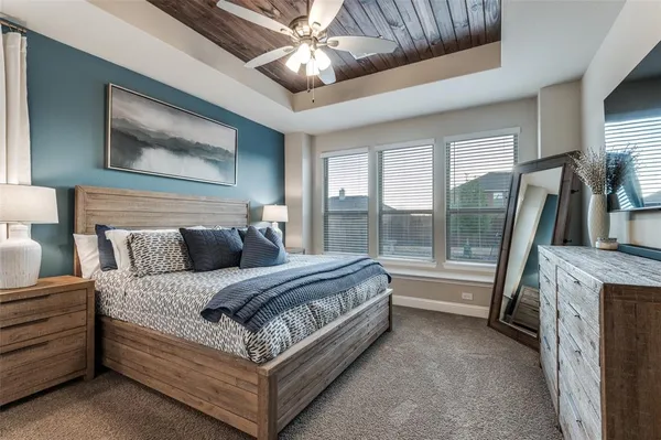 a spacious bedroom with a large bed and a chandelier