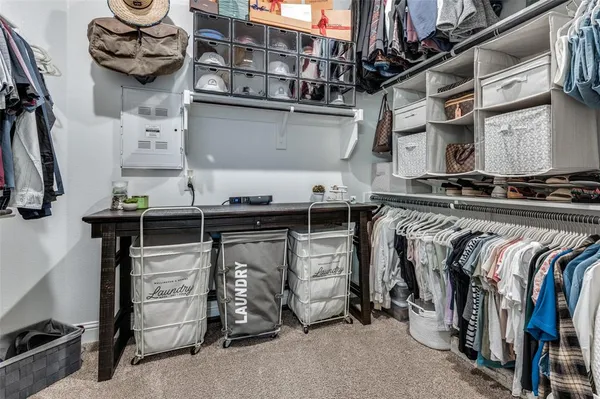 a view of walk in closet with clothes and shoes