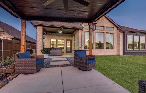 a living room with couches a fireplace and a large window with garden view