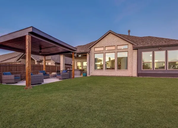 a view of a house next to a big yard with large trees