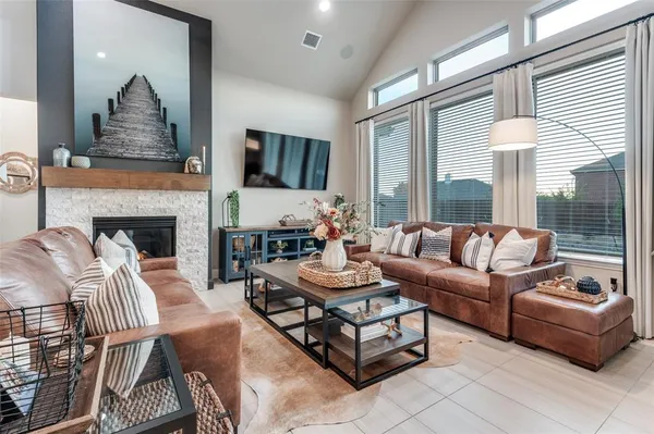 a living room with furniture fireplace and a large window
