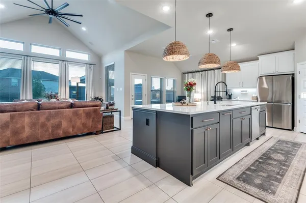 a large kitchen with a large counter space a sink stainless steel appliances and cabinets