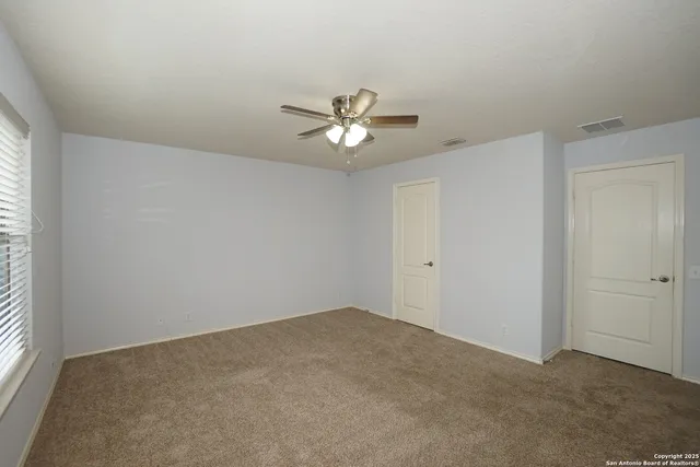 a view of a room with a ceiling fan and a window