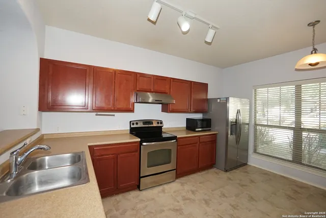 a kitchen with stainless steel appliances granite countertop a sink stove and refrigerator