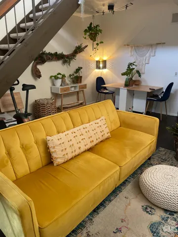 a living room with furniture and wooden floor