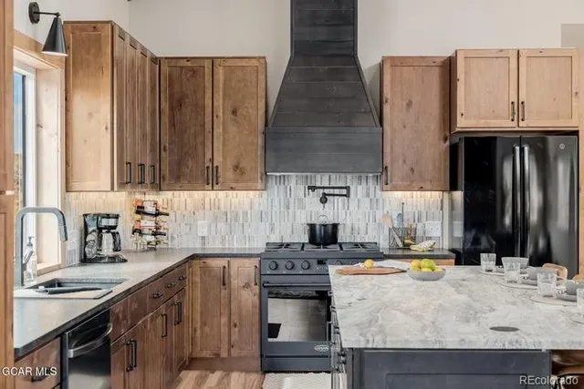 a kitchen with kitchen island granite countertop a sink stove and cabinets