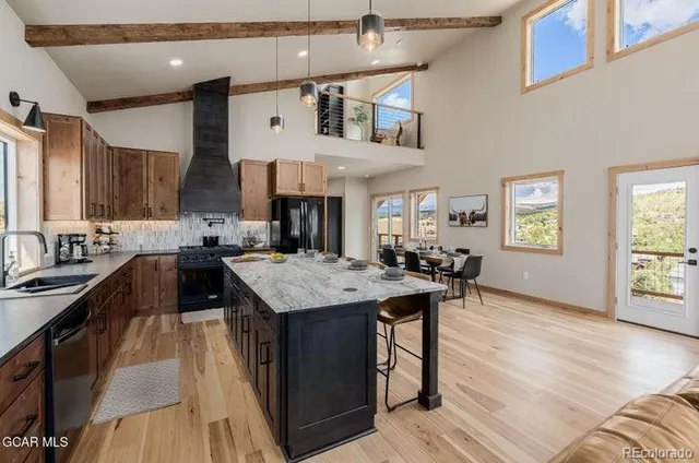 a kitchen with stainless steel appliances granite countertop a sink dishwasher stove and wooden cabinets