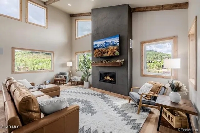 a living room with furniture a flat screen tv and a fireplace