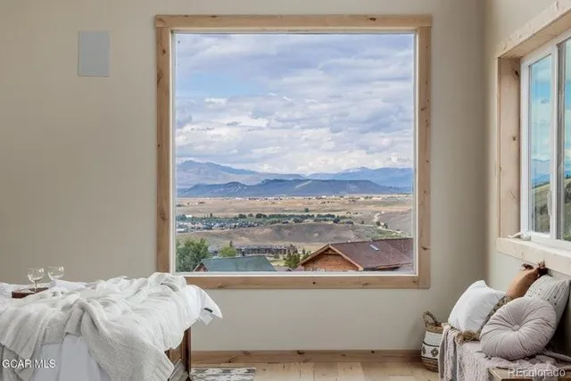 a bedroom with furniture and a large window