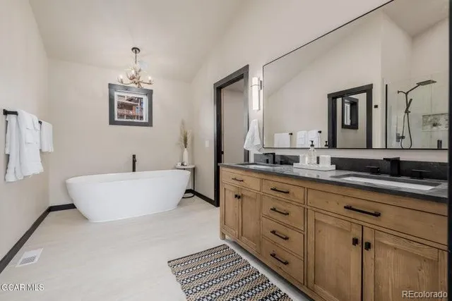 a spacious bathroom with a double vanity sink a mirror and a bathtub