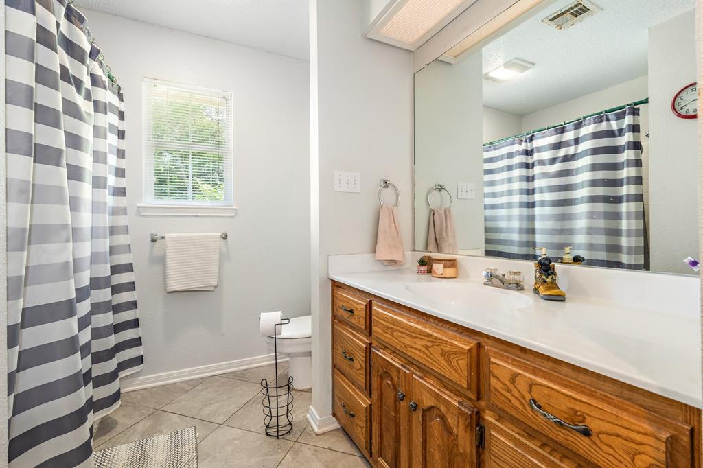 4037 Old Dallas Road Elm Mott, TX 76640 - Photo 23 of 40 a bathroom with a double vanity sink toilet and shower