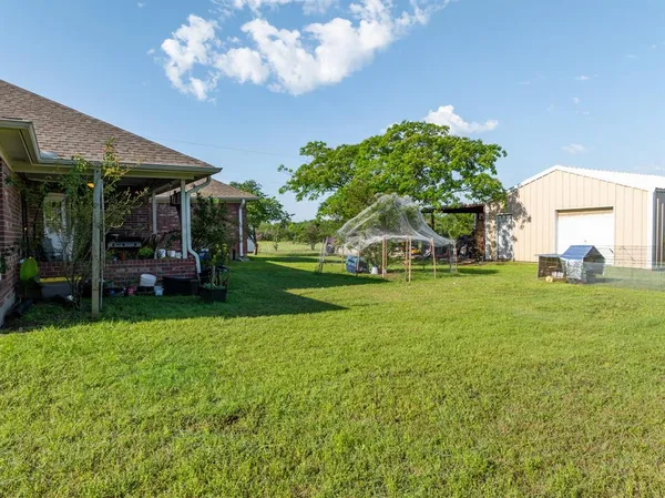 a view of a house with backyard sitting area and swimming pool