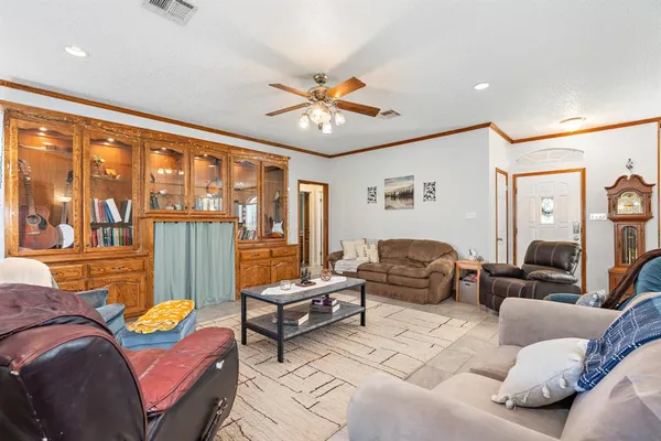 a living room with furniture two window and a chandelier