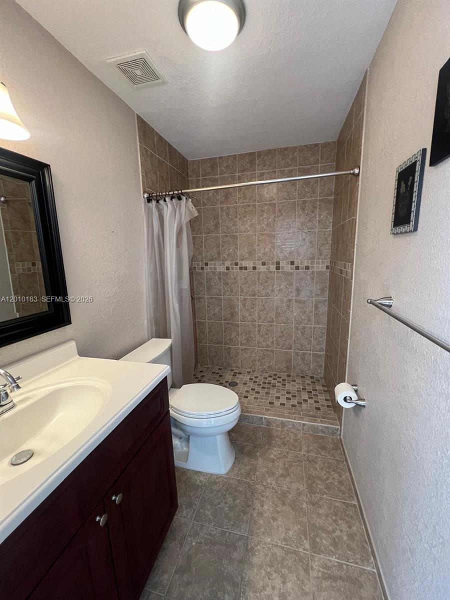 12255 Southwest 29th Terrace Miami, FL 33175 - Photo 2 of 5 a bathroom with a sink a toilet a mirror and shower