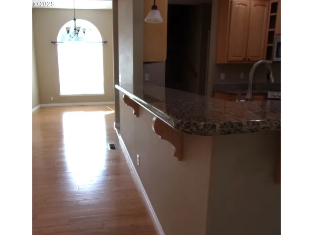a kitchen with granite countertop a stove top oven and cabinets