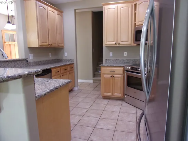a large kitchen with a large counter top space a sink and appliances