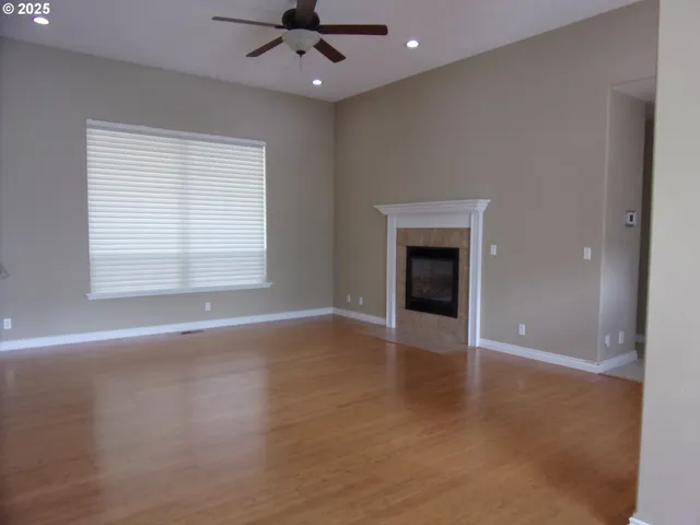 an empty room with wooden floor and a fireplace
