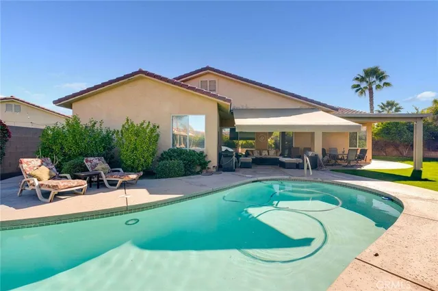 a view of a house with swimming pool and sitting area