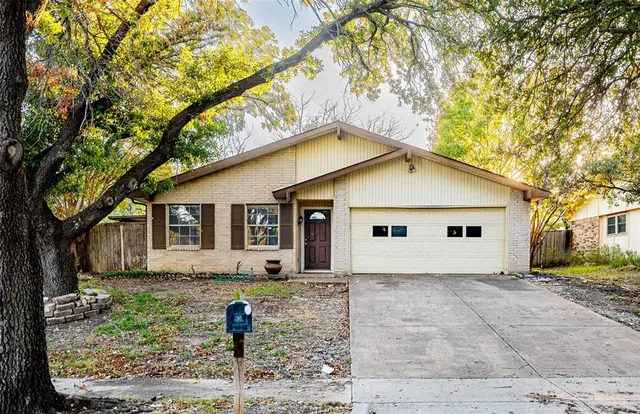 a front view of house with yard and trees around