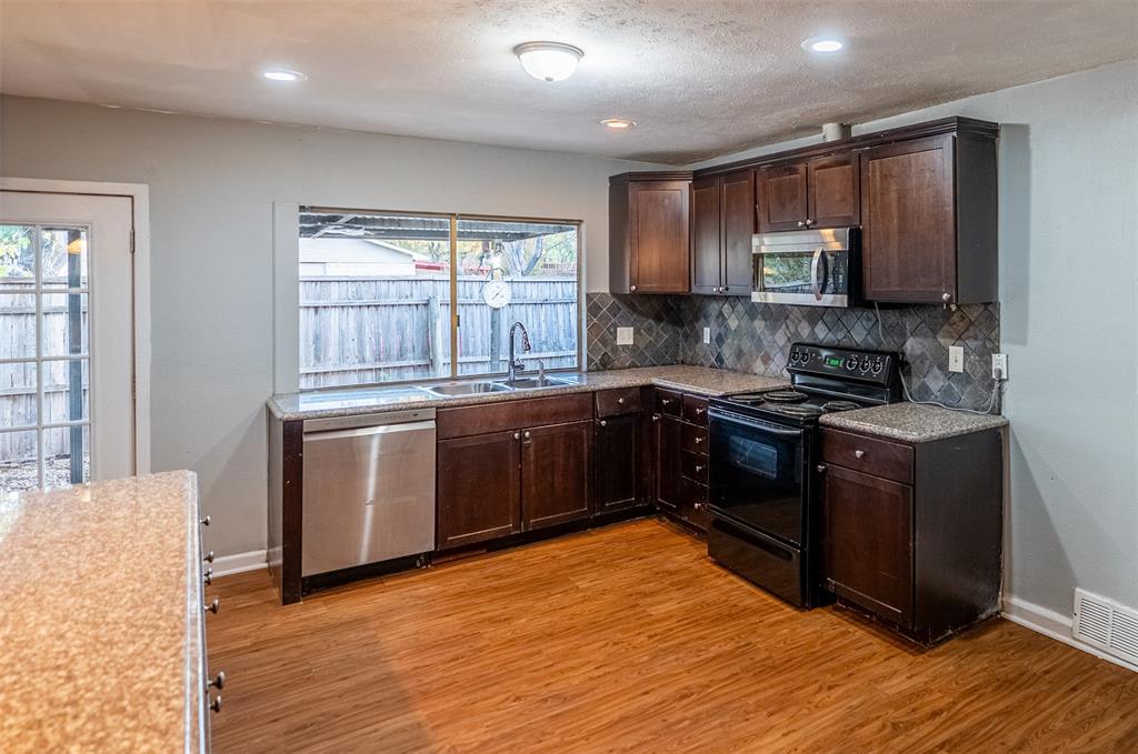 3401 Tarkio Road Plano, TX 75074 - Photo 4 of 11 a kitchen with a sink stove and cabinets