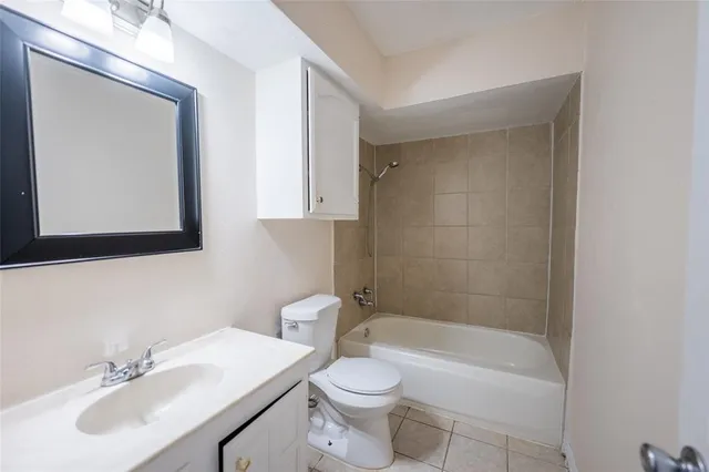 a bathroom with a bathtub shower sink vanity mirror and toilet