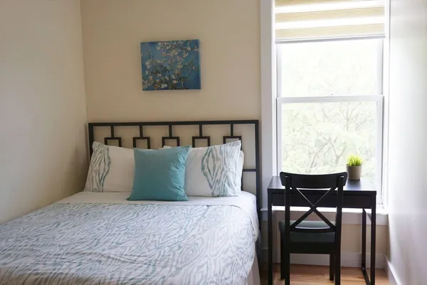 a large bed sitting in a bedroom next to a window
