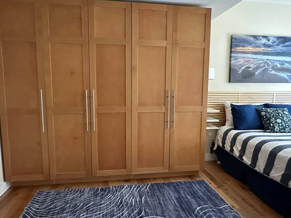 a view of a bedroom with wooden floor and closet