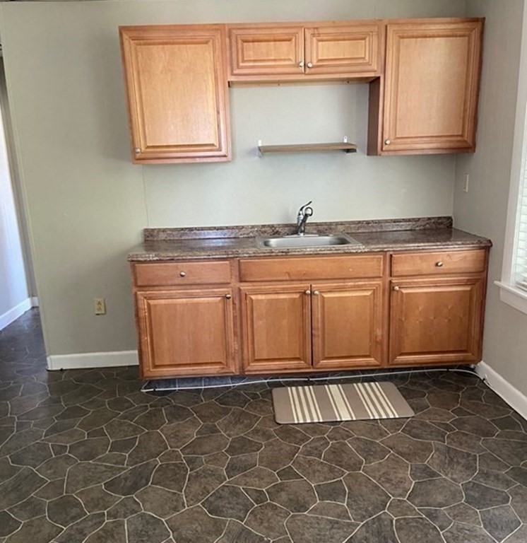 a kitchen with granite countertop a sink and a stove