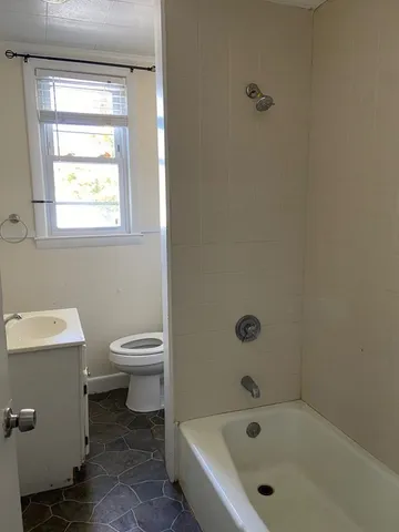 a white bath tub sitting next to a toilet