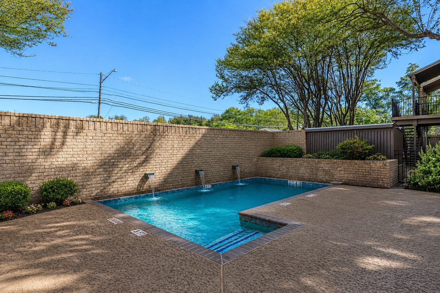 611 East 45th Street, Unit 25 Austin, TX 78751 - Photo 4 of 21 Swimming pool with water features, surrounded by brick walls and mature landscaping
