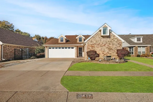 a front view of a house with a garden and yard