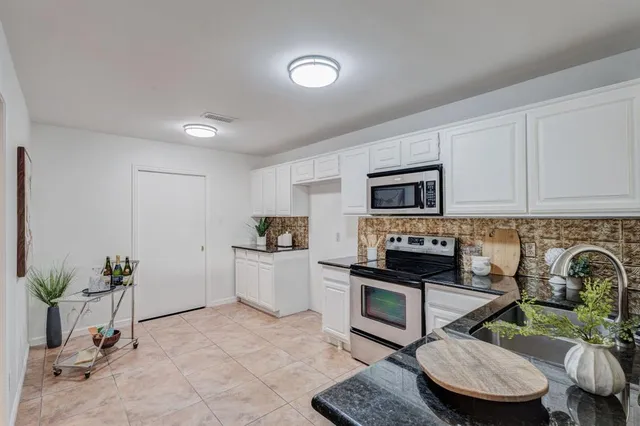 a kitchen with stainless steel appliances a stove a sink cabinets and a refrigerator