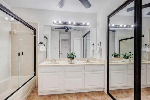 a bathroom with a sink a large mirror and a shower