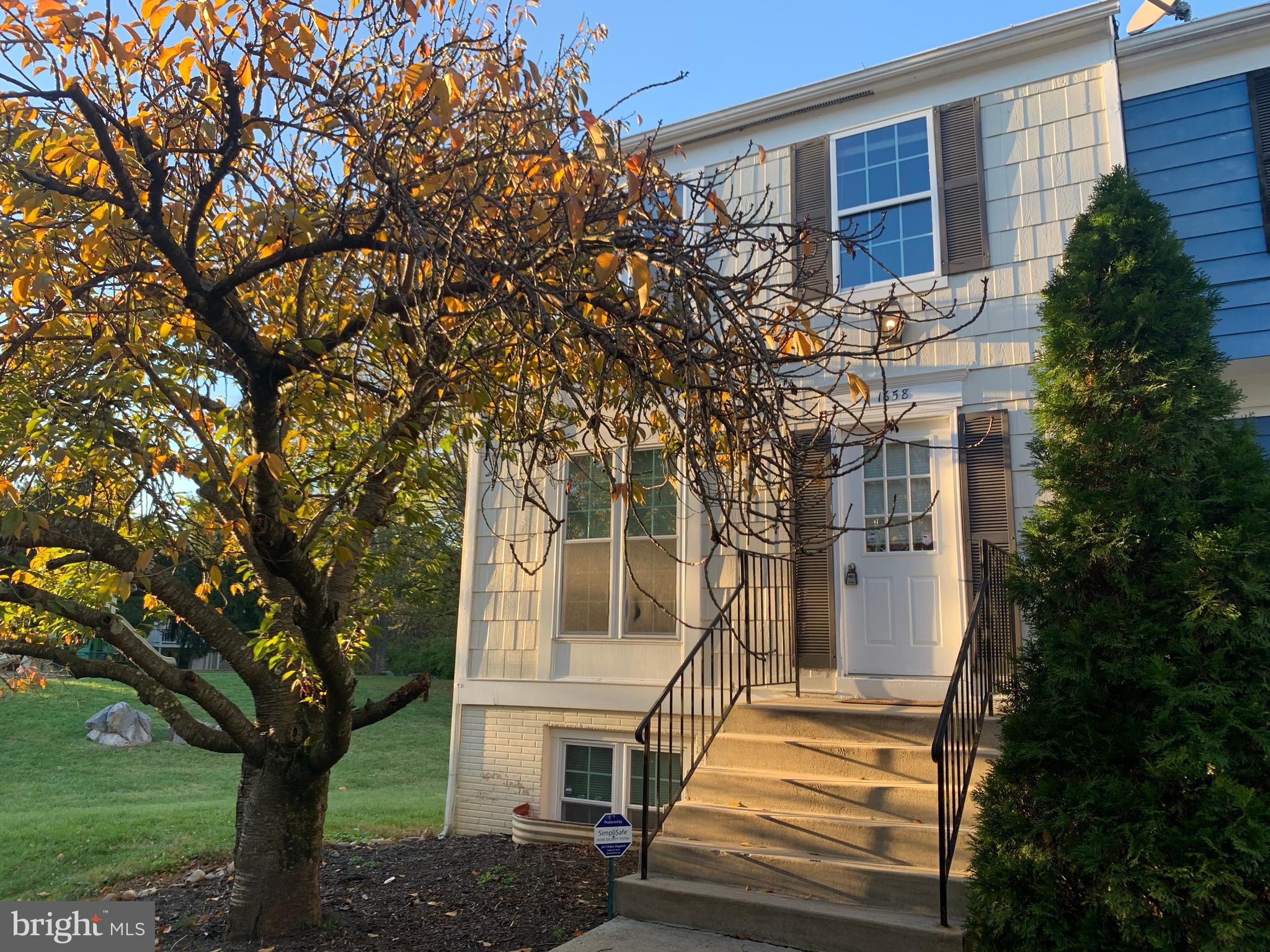 a front view of a house with a tree