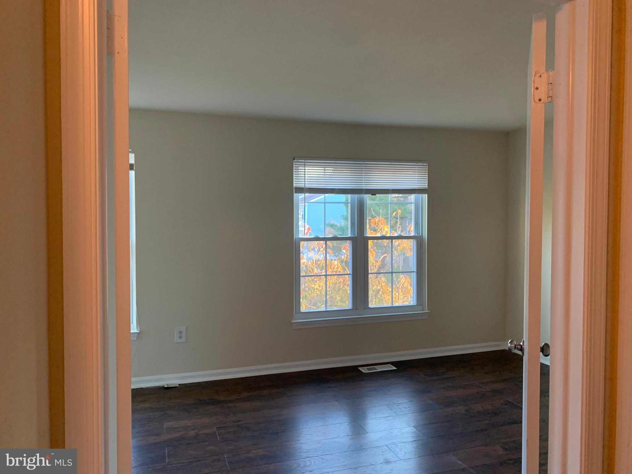 1658 Colonial Way Frederick, MD 21702 - Photo 13 of 32 a view of an empty room with wooden floor and a window