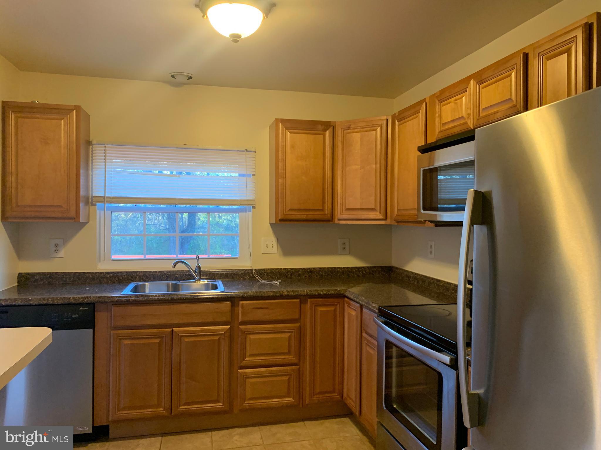 1658 Colonial Way Frederick, MD 21702 - Photo 9 of 32 a kitchen with granite countertop a sink stove and refrigerator