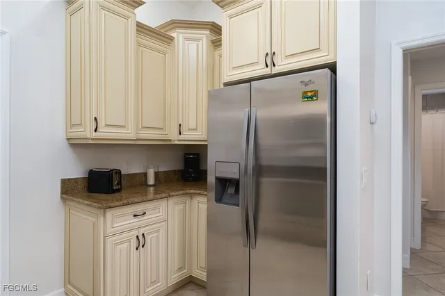 a kitchen with white cabinets and refrigerator