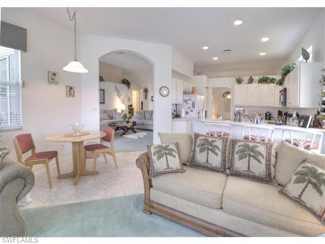 400 Harvard Court Naples, FL 34104 - Photo 3 of 16 a living room with furniture a chandelier and a dining table