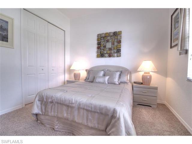 400 Harvard Court Naples, FL 34104 - Photo 8 of 16 a bedroom with a bed and a night stand