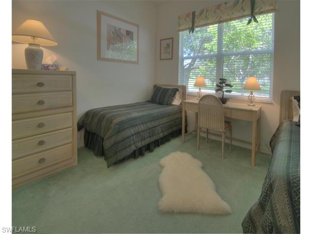 400 Harvard Court Naples, FL 34104 - Photo 9 of 16 a spacious bedroom with a bed and large windows