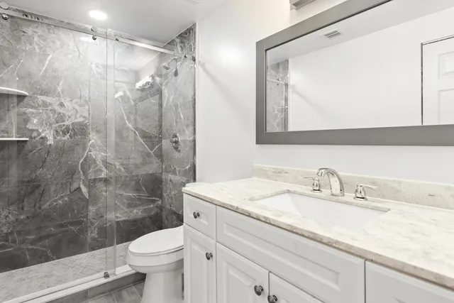 a bathroom with a toilet sink and mirror
