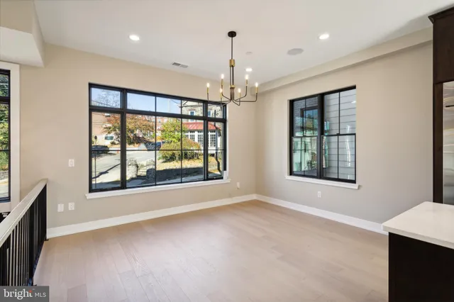 a view of an empty room with a window and chandelier