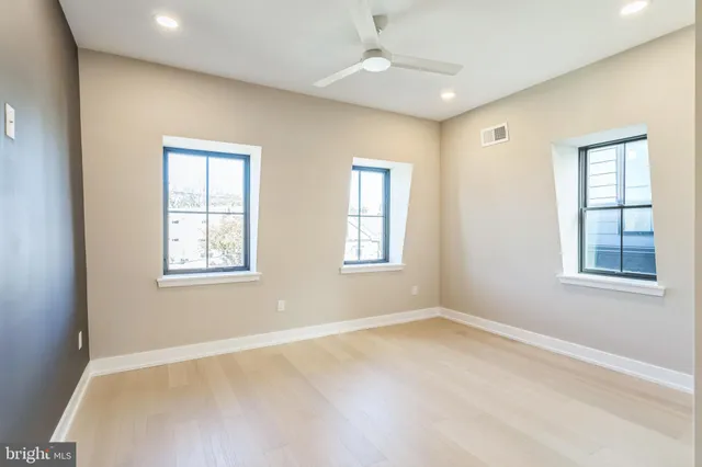 an empty room with windows and closet
