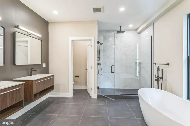 a bathroom with a double vanity sink toilet and shower