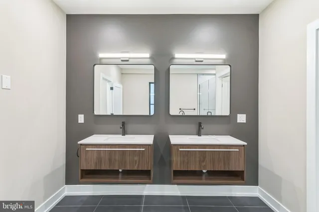 a bathroom with double vanity and a mirror